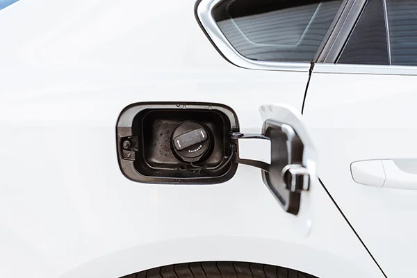 White vehicle with open fuel door showing gas cap