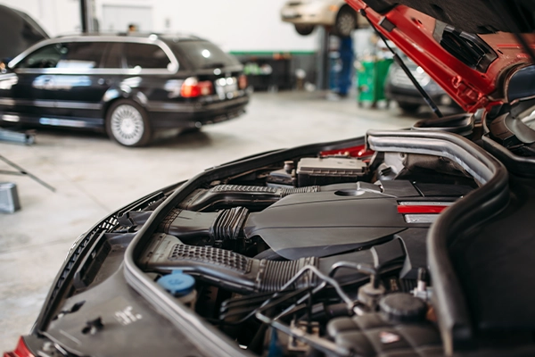 Red vehicle with hood open showing engine bay
