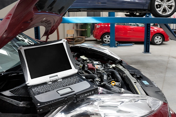 Inspection laptop sitting on car's engine bay