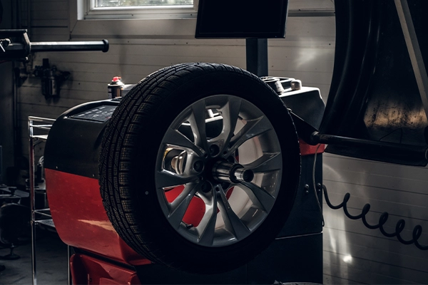 Tire being balanced on red machine