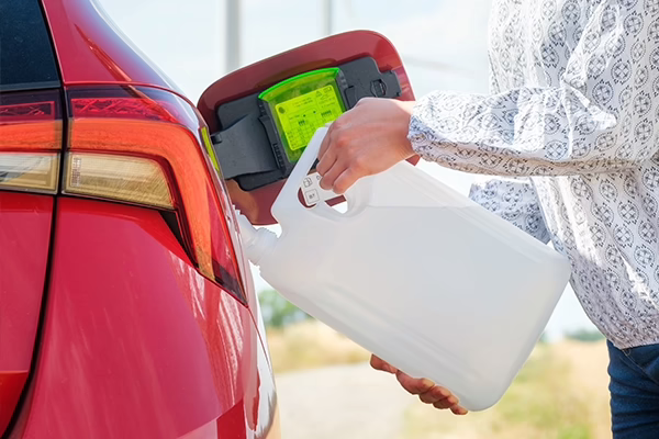 Woman filling car with diesel exhaust fluid through filler port